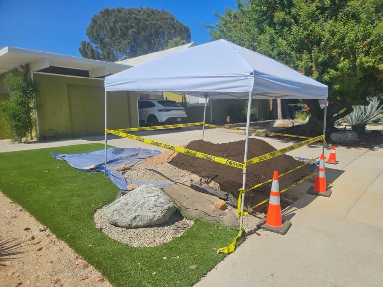 Excavation protected by canopy, cones and barrier tape