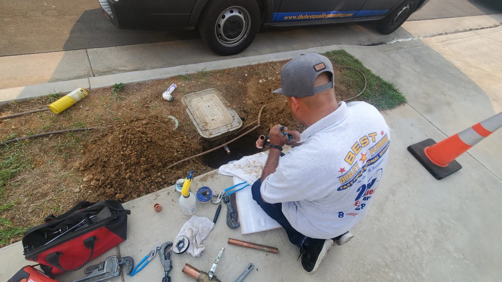 Plumber with testing equipment at an exterior water access point