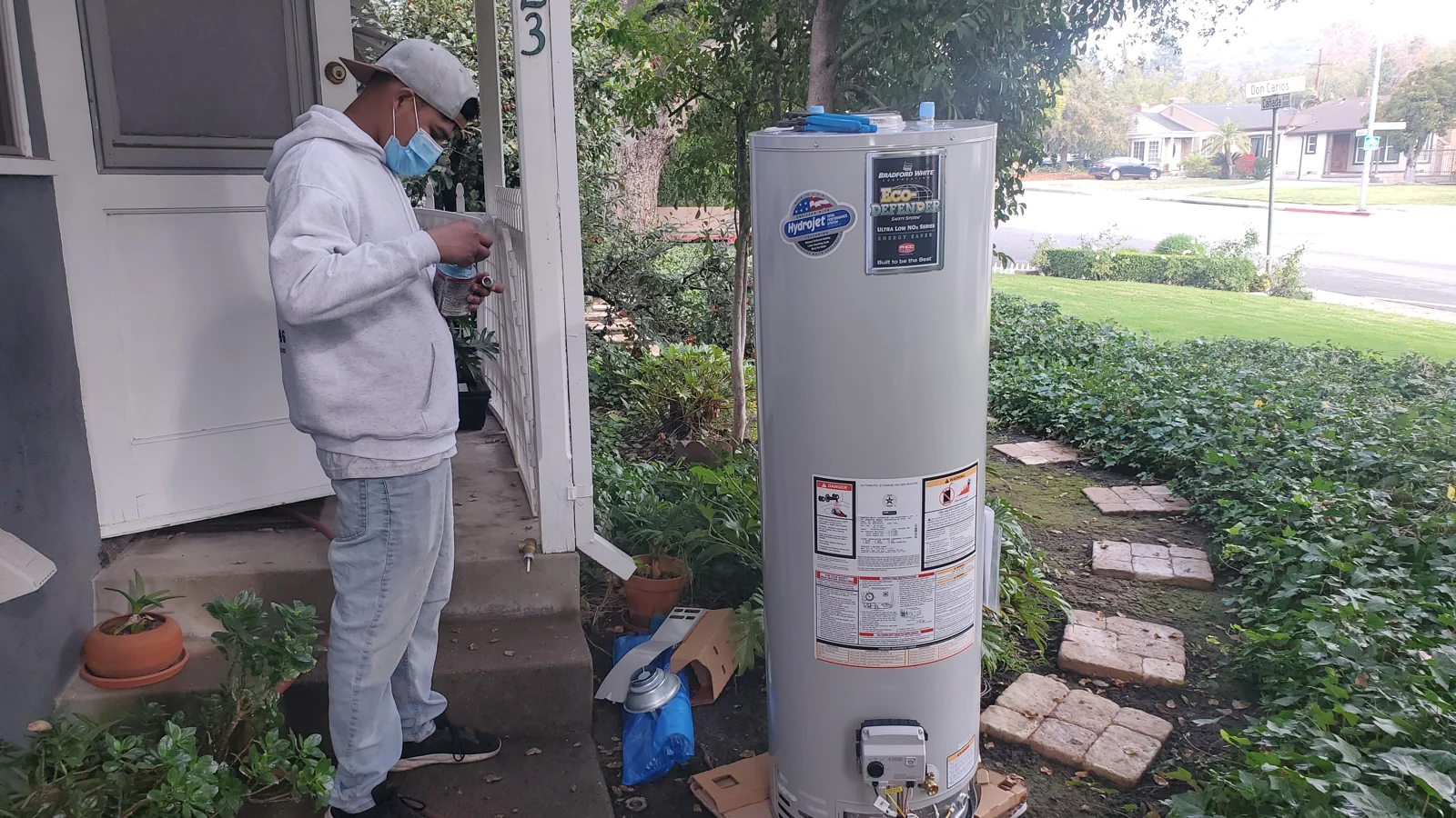 Plumber beside a tank water heater prepared for installation