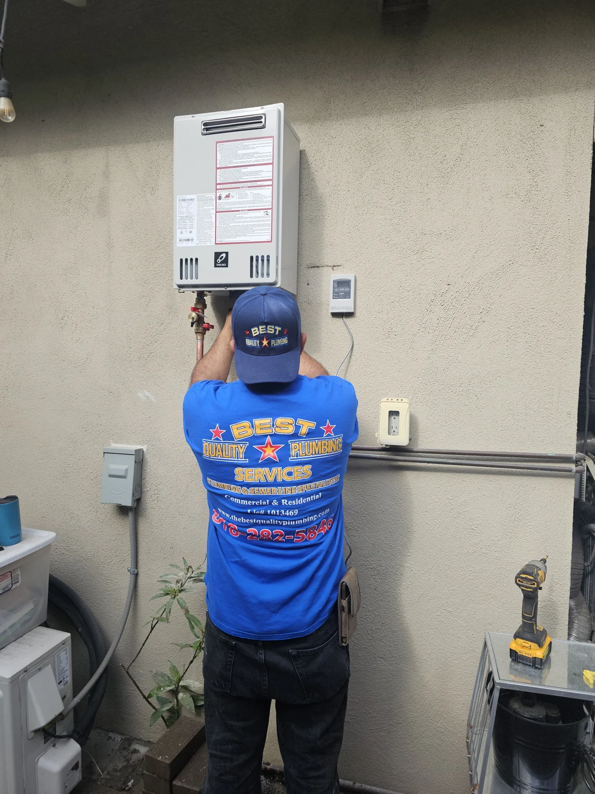 Plumber working on a wall-mounted tankless water heater